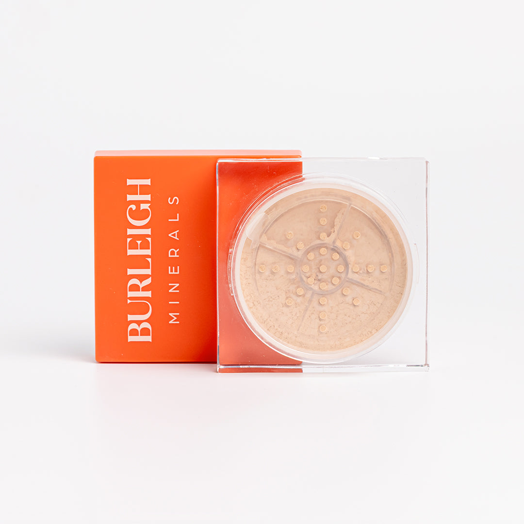 Clear container of mineral highlighter powder with a light orange lid, photographed against a white background.