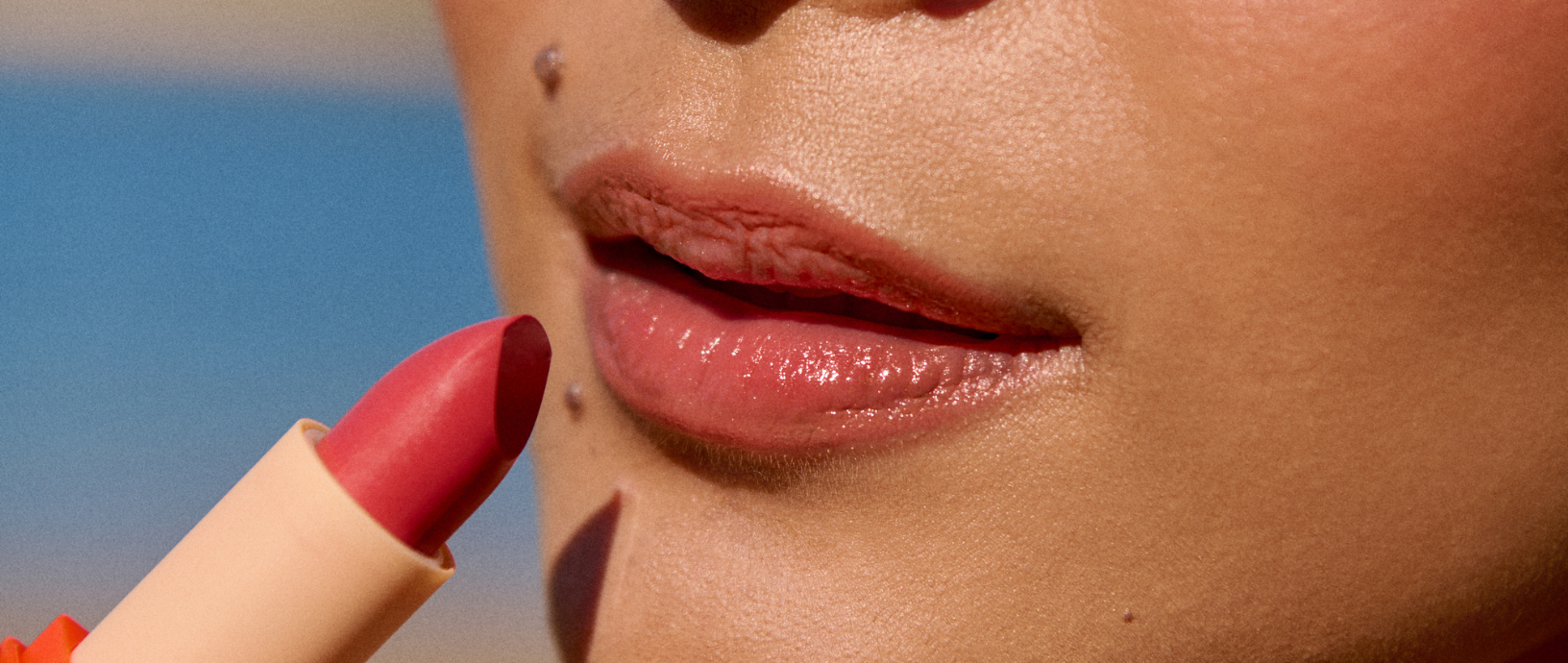 Applying Burleigh Minerals Longwear Lipstick to lips in the shade Cherry Kisses