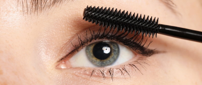 Up close shot applying black mascara to eyelashes.