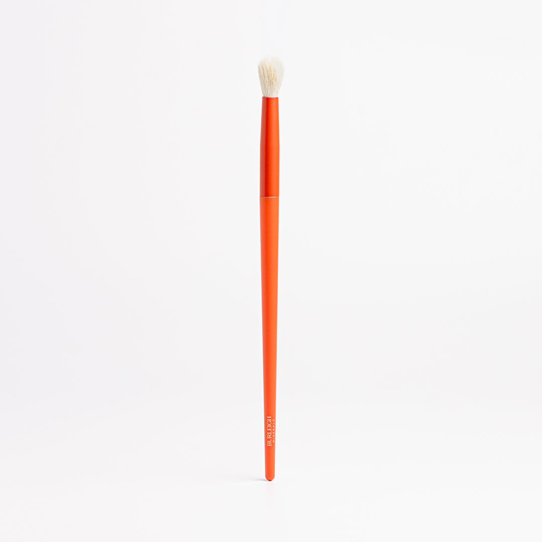Blending Eye Shadow vegan makeup Brush with white bristles and an orange handle is used to blend and diffuse eyeshadow in your crease for a smooth transition between shades.