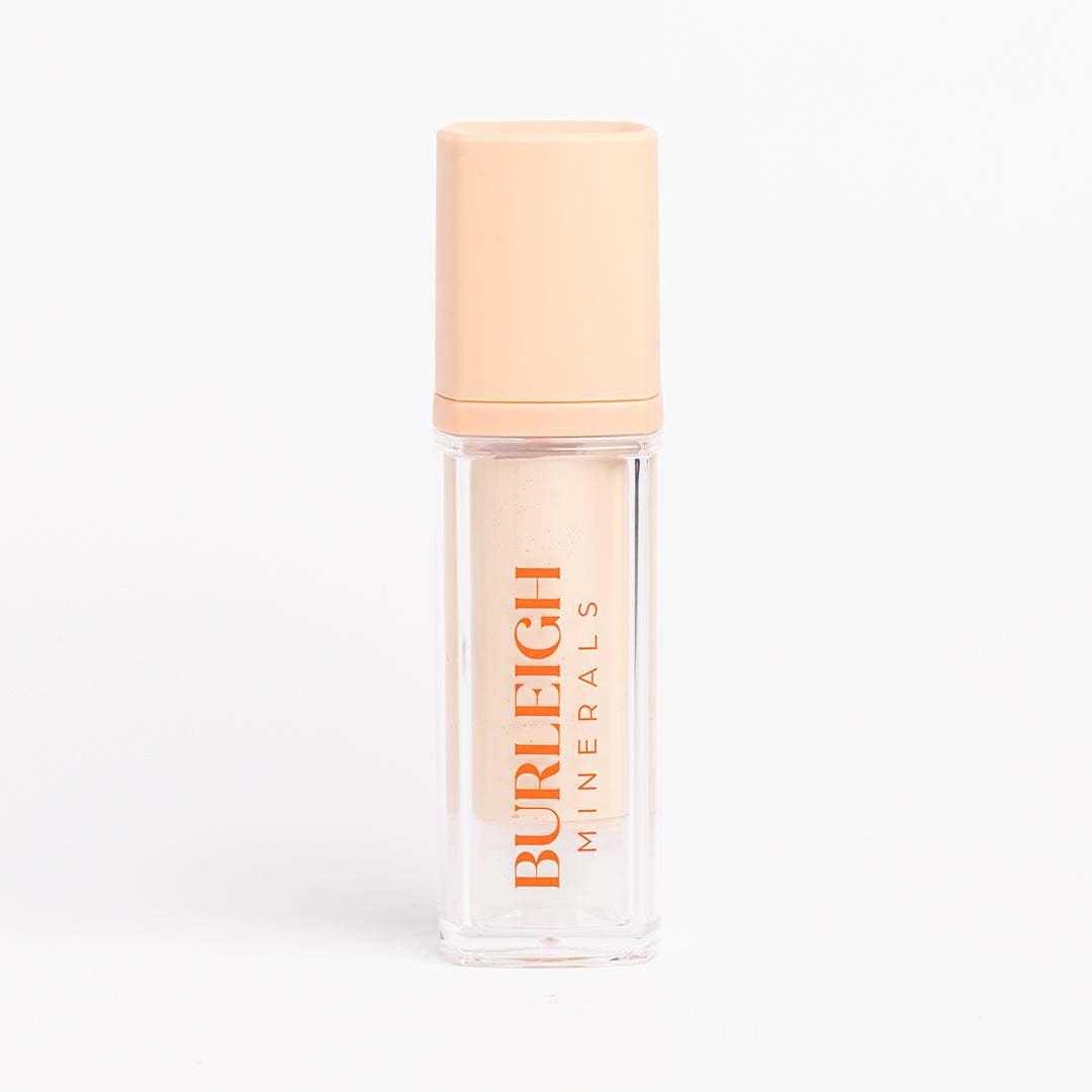 Clear bottle of liquid earth cream tinted moisturiser in the shade 110 pearl with a pastel orange lid, photographed against a white background.