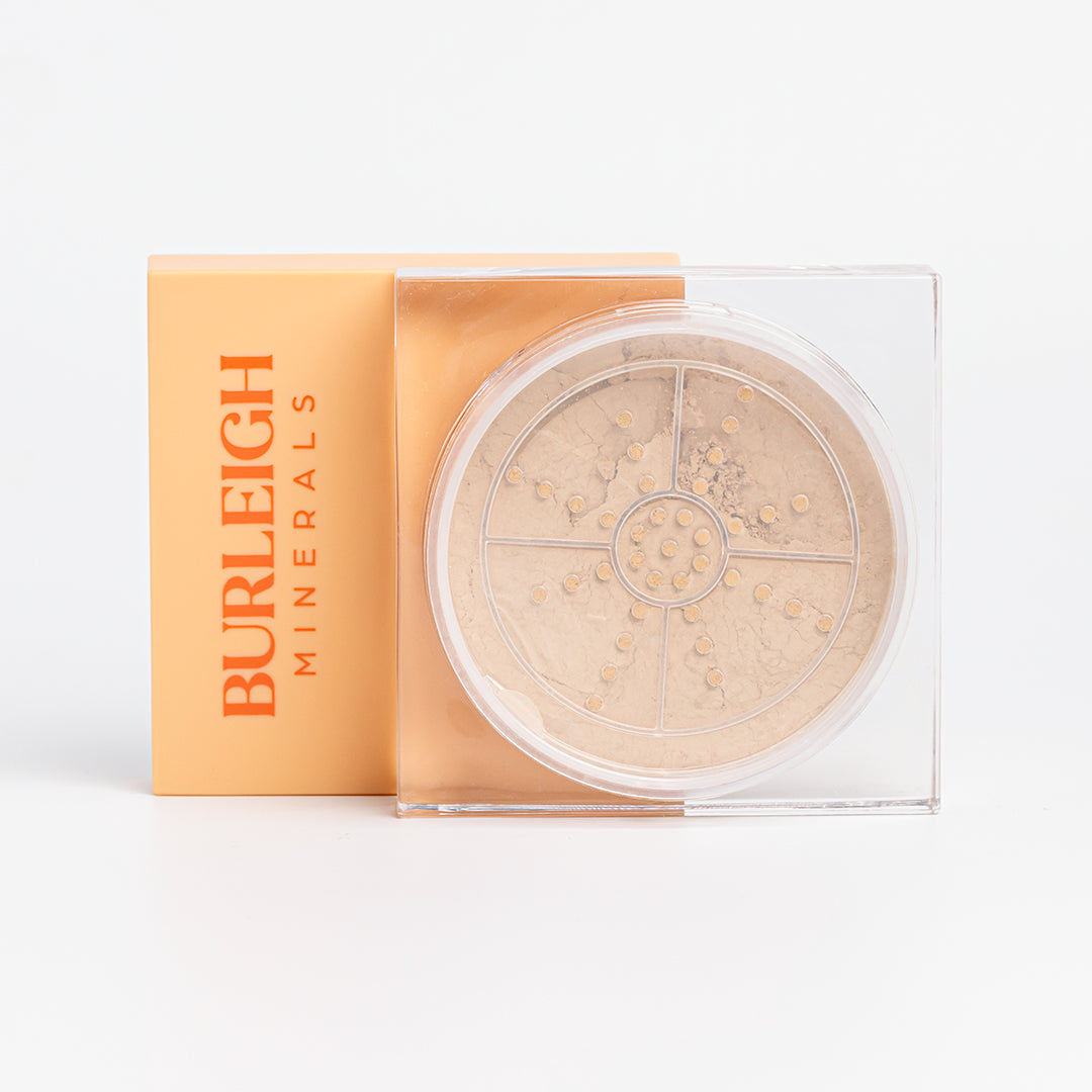 Clear container of mineral foundation powder in the 140 sea shell with a pastel orange lid, photographed against a white background.