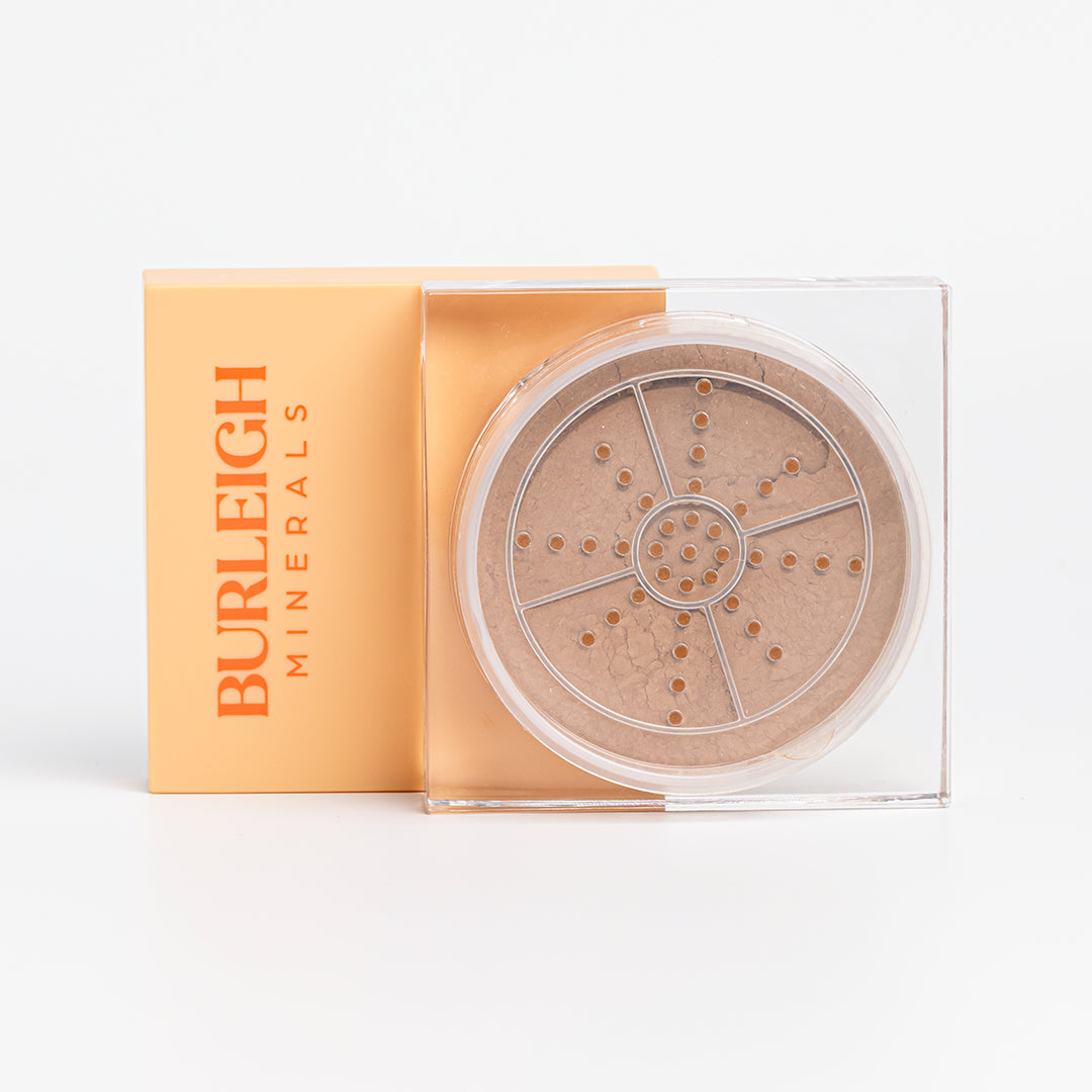 Clear container of mineral foundation powder in the 330 burleigh bronze with a pastel orange lid, photographed against a white background.