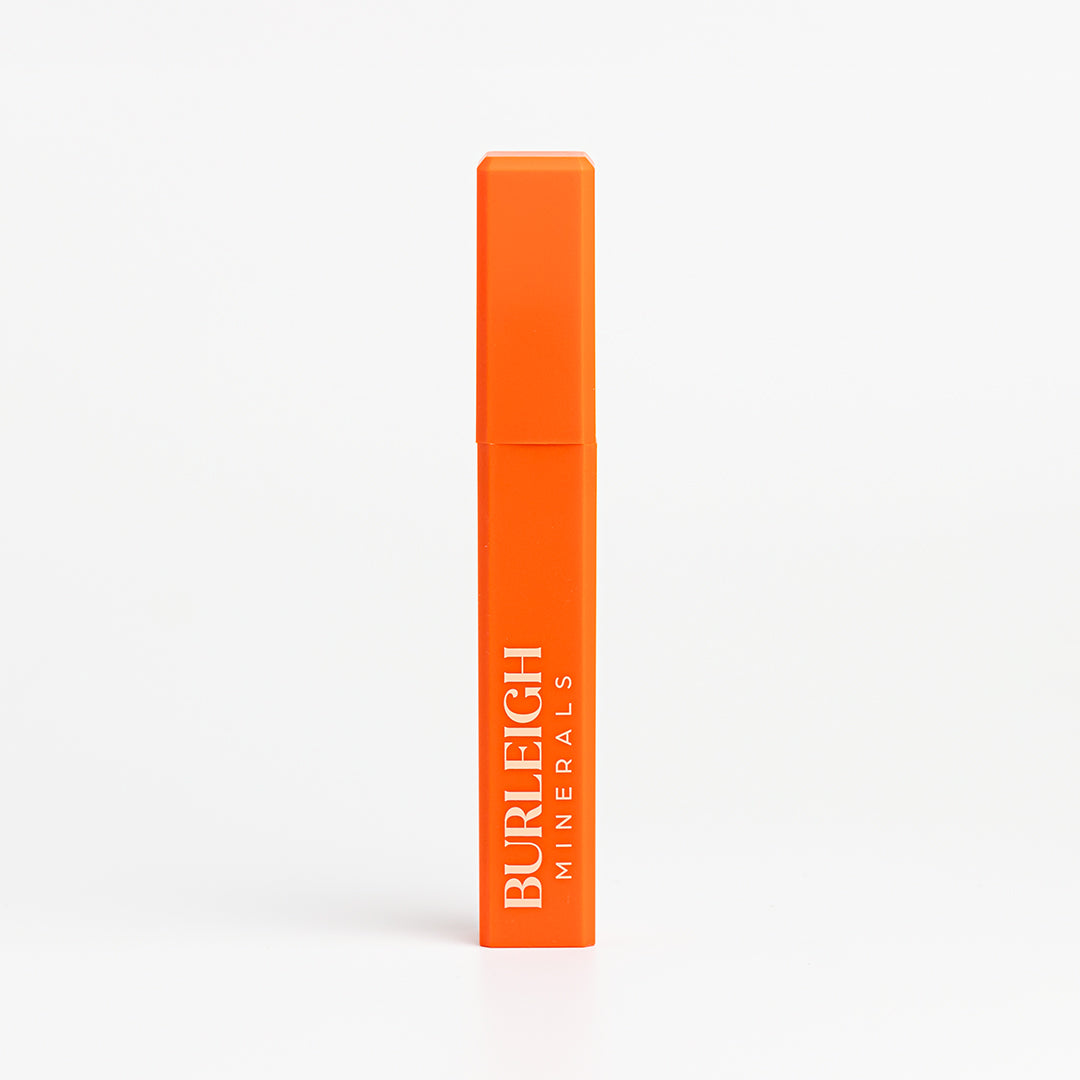 Water-resistant, black mineral mascara in bright orange packaging, photographed against a white background.